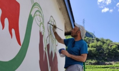 Lo street artist DEM lavora ad un murales con gli studenti