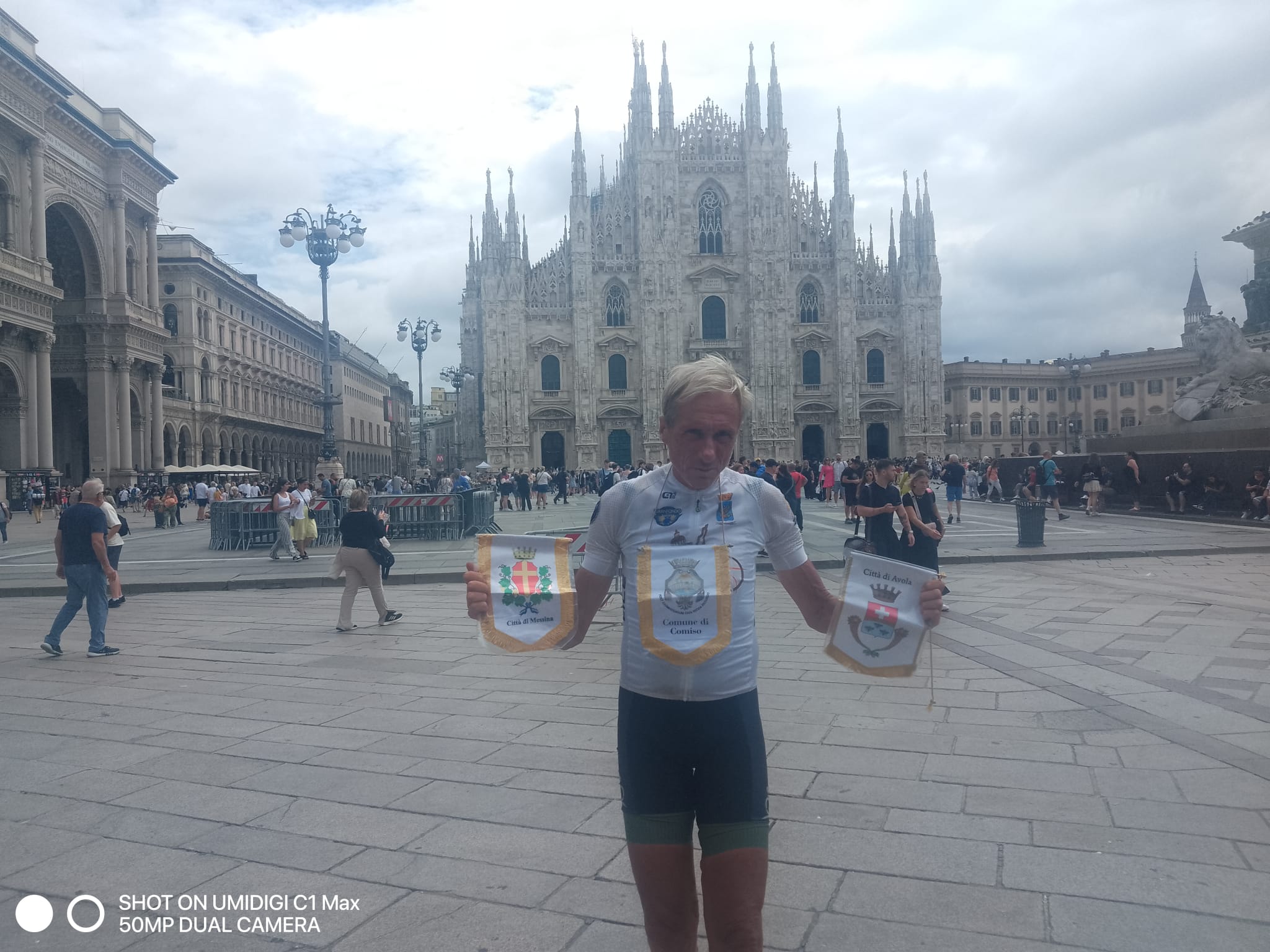 Leonardo Cavazzi nella piazza del Duomo di Milano con due gagliardetti di comuni attraversati